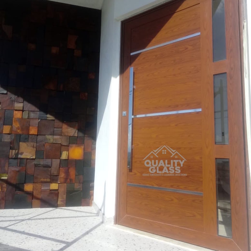 Entrada residencial com porta e painel lateral envidraçado