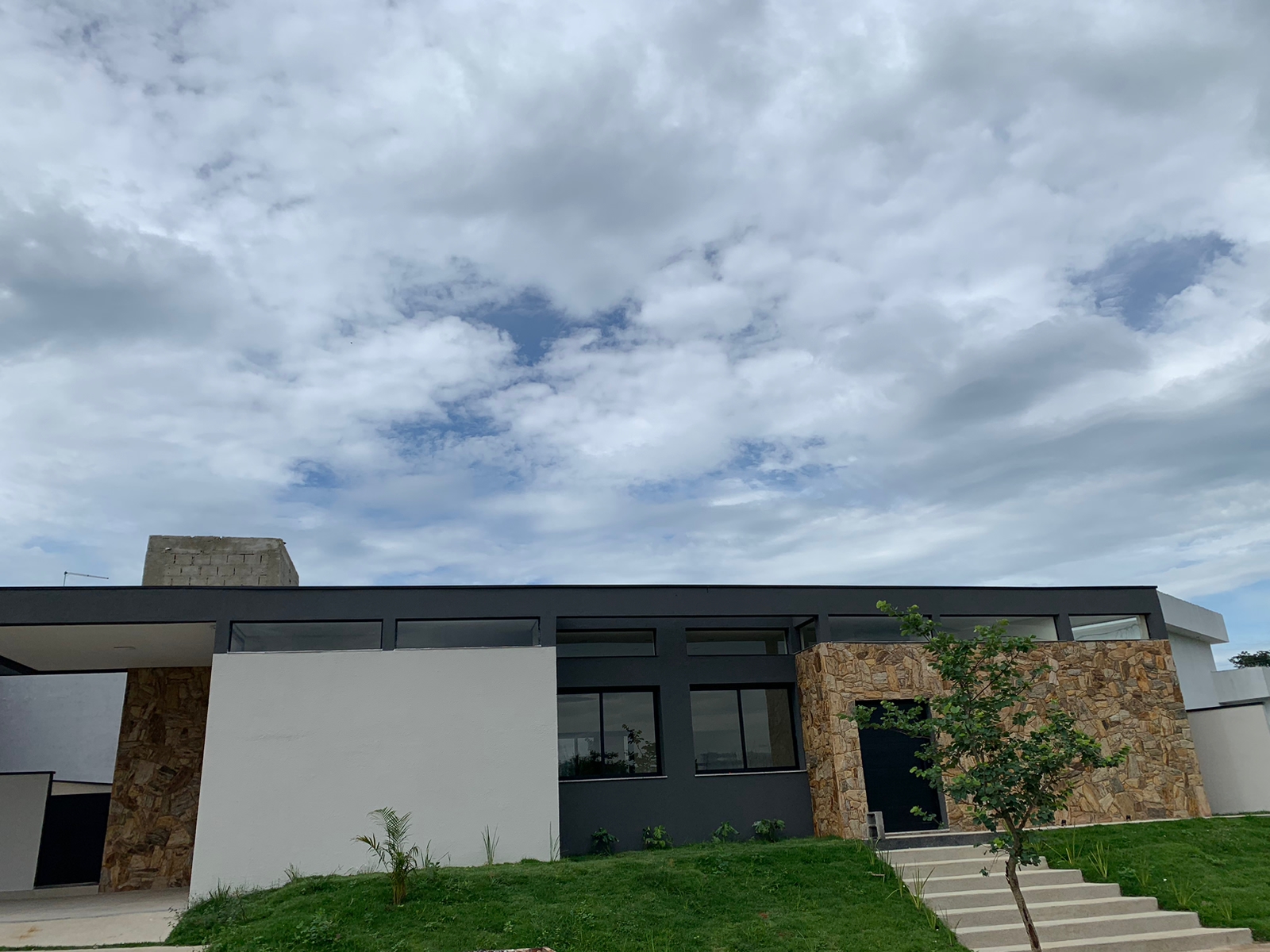 Fachada escura com amplas esquadrias de alumínio