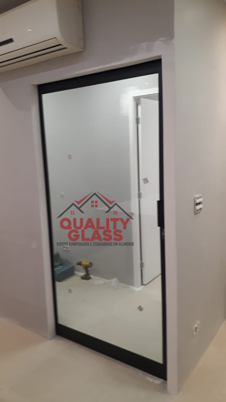Porta de vidro com perfil escuro em ambiente interno