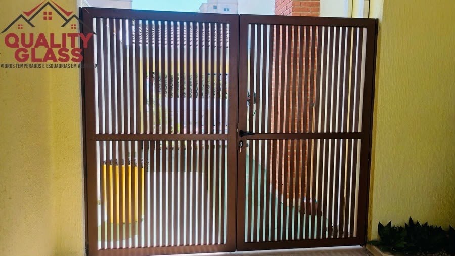 Portão de abrir com ripas verticais escuras