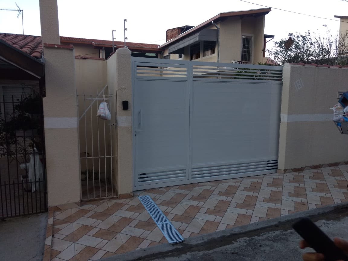 Portão de correr cinza em entrada residencial