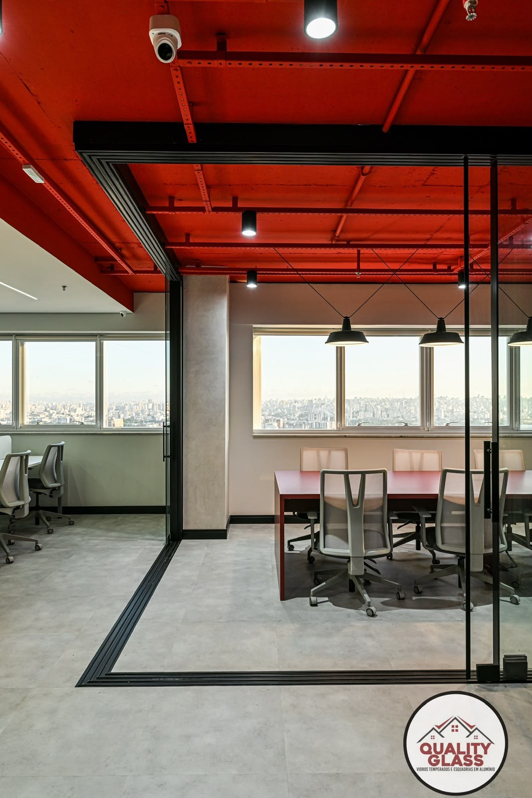 Sala comercial com esquadrias escuras e fechamento de vidro