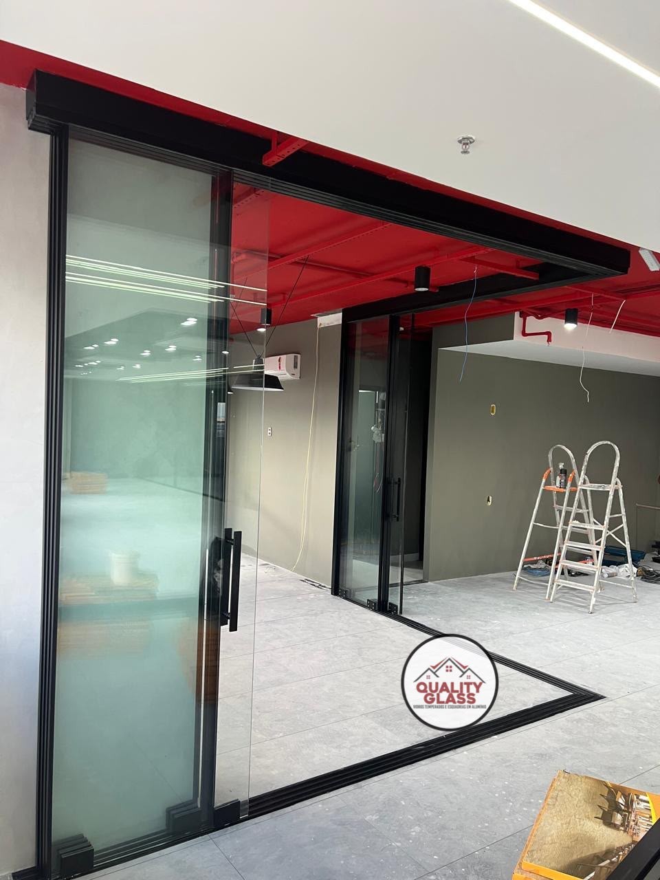 Sala comercial com divisórias de vidro e estrutura aparente